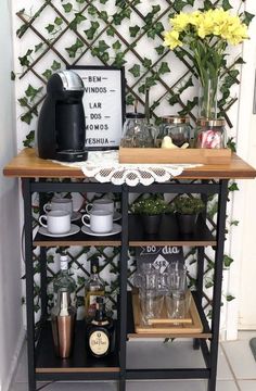 a coffee bar with cups and mugs on the shelf next to it is decorated with yellow flowers