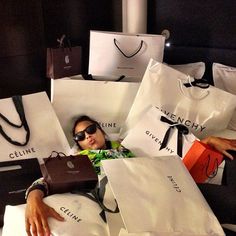 a man laying on top of a bed with lots of bags in front of him