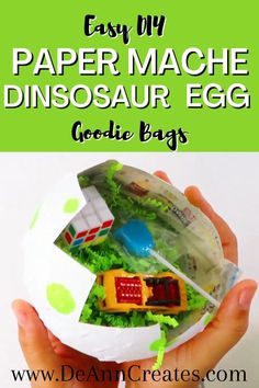 The pin shows a paper mache dinosaur egg filled with crinkle paper and party favors held by a pair of hands. Diy Goodie Bags, Diy Party Bags, Diy Paper Mache