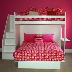 a white bunk bed with pink and orange pillows on it's bottom shelf next to a red wall