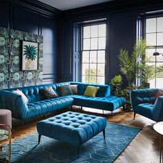 a living room with blue couches and green wallpaper on the walls in front of two large windows