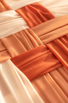 an orange and white dress with pleated details on it's sides, close up