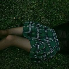 a person laying in the grass with their legs crossed