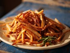 a white plate topped with french fries on top of a wooden table