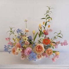 a vase filled with lots of different colored flowers