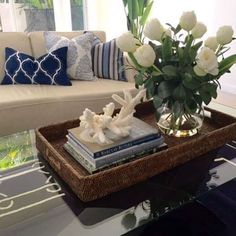 a coffee table with flowers and books on it