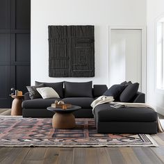 a living room filled with black furniture and pillows