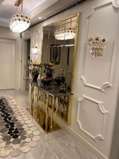 a room with a mirror, chandelier and rugs on the floor in front of it