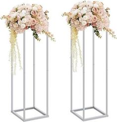 two metal vases with flowers in them are shown side by side on a white background