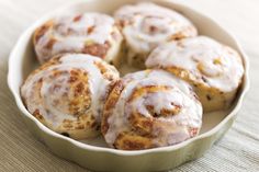 cinnamon rolls with icing in a bowl on a table