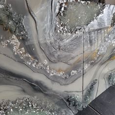 an abstract painting with silver and black colors