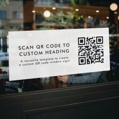 a close up of a window with a sign in the glass that says scan qr code to custom heading