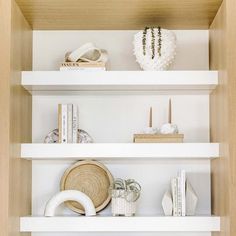 white shelves with books and vases on them