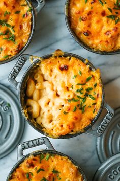 macaroni and cheese casserole is shown in four pans on a marble surface