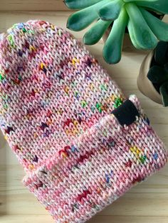 a pink knitted mitt next to a potted plant