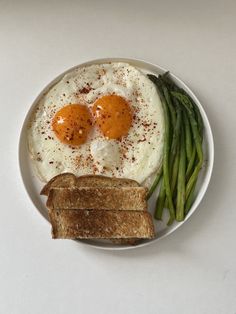 an egg, toast and asparagus on a plate