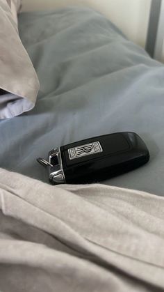 a black remote control laying on top of a bed