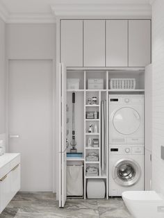 a washer and dryer in a small room with white cabinets on the walls