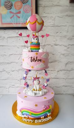 a three tiered birthday cake decorated with balloons