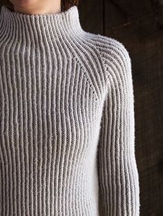 a woman wearing a white turtle neck sweater