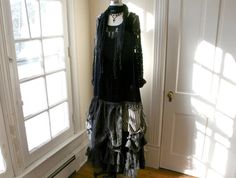 a black dress on display in front of a door with sunlight coming through the window