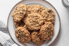 a plate full of oatmeal cookies next to a glass of milk