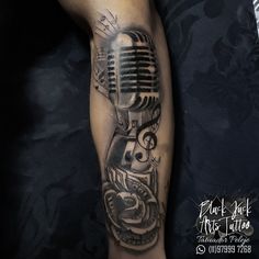 a man's arm with a microphone tattoo on it