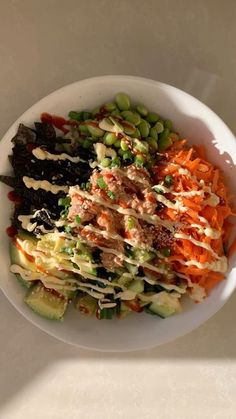 a white bowl filled with lots of different types of food on top of a table