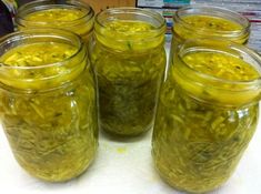 several jars filled with pickles sitting on top of a table