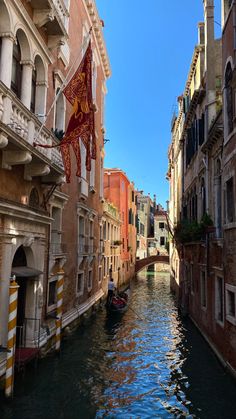 a boat is going down the canal in venice, italy with buildings lining both sides