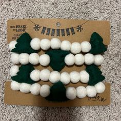 white balls and green felt christmas trees on a brown carded cardboard package for sale