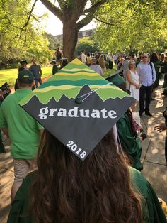 a graduation cap with the words graduate on it in front of a group of people