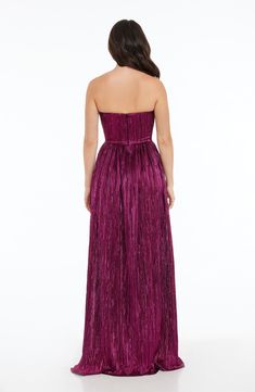 a woman in a purple strapless dress looking down at the back of her gown