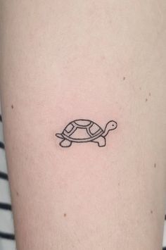 a small turtle tattoo on the right side of the thigh, it is black and white