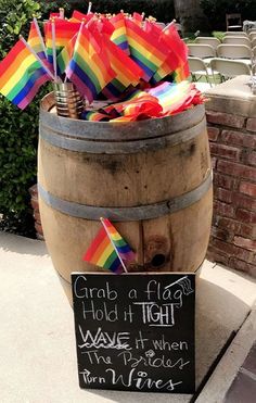 a wooden barrel filled with umbrellas next to a chalkboard saying grab a flag hold it tight