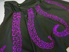 the purple and black dress has an intricate design on it's side, as well as two large circles