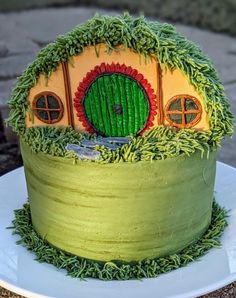 a cake decorated with grass and a house