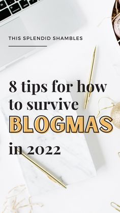 a desk with a laptop, pen and other items on it that says 8 tips for how to survive blogmas in 2020