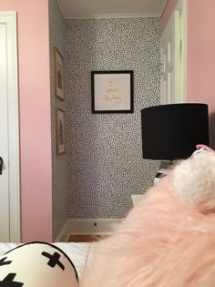 a bedroom with pink walls and black and white wallpaper