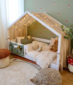 a child's bedroom with a tent bed and stuffed animals on the rugs