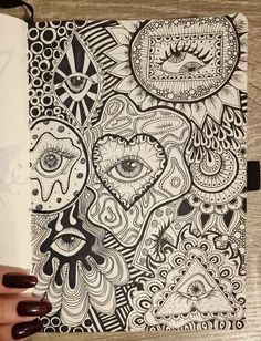 a notebook with black and white doodles on it, featuring an image of eyeballs