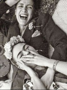 an old black and white photo of a woman laughing with her hands on her face