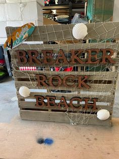 a wooden sign that says breaker rock beach with seashells on the bottom