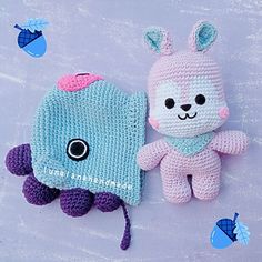 two crocheted stuffed animals sitting next to each other on a table with blue and pink decorations