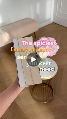 a person holding up a book in front of a table with flowers on it and the words, the spicelist fantasy romance series never need