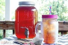 two mason jars filled with liquid sitting on top of a table