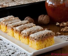 there are several pieces of cake on the plate next to some walnuts and honey