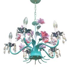 a green chandelier with pink flowers and crystal drops hanging from it's center