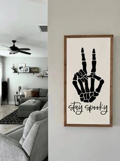 a living room with a couch and a poster on the wall that says stay spooky