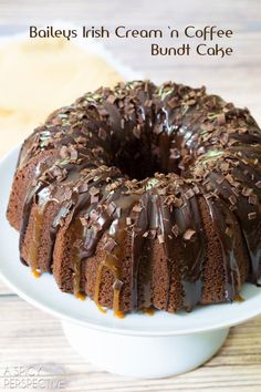 a bundt cake with chocolate frosting and sprinkles on top sitting on a white plate